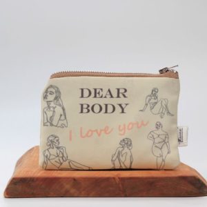dear body i love you theone' designs toiletry bag on a wooden board with a white background