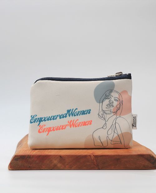 empowered women empower women theone' designs toiletry bag on a wooden board with a white background